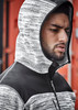 A unisex reinforced knit hoodie in black and grey, featuring a hood and a zip closure, displayed on a model. A unisex reinforced knit hoodie in black and grey, featuring a hood and a zip closure, displayed on a model.