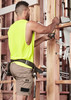 A man wearing khaki cargo shorts and a bright yellow sleeveless top, working with tools on a construction site. A man wearing khaki cargo shorts and a bright yellow sleeveless top, working with tools on a construction site.