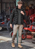 Men's essential basic stretch cargo pants in beige, paired with a black puffer jacket and tan boots, set in an outdoor environment. Men's essential basic stretch cargo pants in beige, paired with a black puffer jacket and tan boots, set in an outdoor environment.
