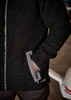 A black unisex full zip sherpa fleece jumper with side pockets and a logo.