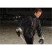Men's Axis Thermal Jacket in black with orange accents, worn by a person on an ice rink, holding a hockey stick.