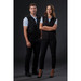 A black softshell vest is worn by a man and woman standing together against a dark background. The vest features a logo. A black softshell vest is worn by a man and woman standing together against a dark background. The vest features a logo.