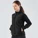 A woman is wearing a black ultra-light shell jacket, featuring a zippered front and side pockets.