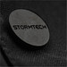 A close-up of a dark textured fabric featuring a circular black logo with the word "STORMTECH." A close-up of a dark textured fabric featuring a circular black logo with the word "STORMTECH."