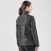 A women's rain jacket in dark grey, featuring a high collar and a flap at the back, with a logo present.