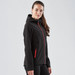 A black softshell hoody with a red zipper and accents, featuring a hood and zippered pockets, displayed on a model.