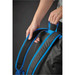 A person's hand holds the padded blue strap of a black backpack, showcasing its design and features. A person's hand holds the padded blue strap of a black backpack, showcasing its design and features.