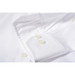 A white button-up shirt featuring a classic collar and pearl buttons on the cuffs. It has a branding logo. A white button-up shirt featuring a classic collar and pearl buttons on the cuffs. It has a branding logo.
