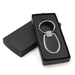 A sleek silver keychain with an oval design, presented in a black box.