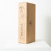 A wine bottle holder in a cardboard box, featuring a design illustration and a logo, displayed on a white surface.