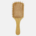 A bamboo hairbrush with a wooden handle and bristles, featuring a rectangular paddle design.