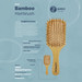 A bamboo hairbrush with a wooden handle and bristles, featuring a kraft sleeve and a logo.