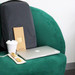 A grey Nova Computer Backpack rests on a green chair beside a laptop, a coffee cup, and a packet of bamboo straws.