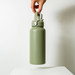A drink bottle in matte olive green, featuring a sturdy handle and a silver accent, with a logo displayed. A drink bottle in matte olive green, featuring a sturdy handle and a silver accent, with a logo displayed.