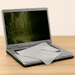 A grey microfibre laptop screen protector placed over an open laptop on a wooden surface.