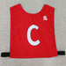 Red pull-over elastic netball bib featuring a prominent white 'C' and a logo. Ideal for sports uniforms.