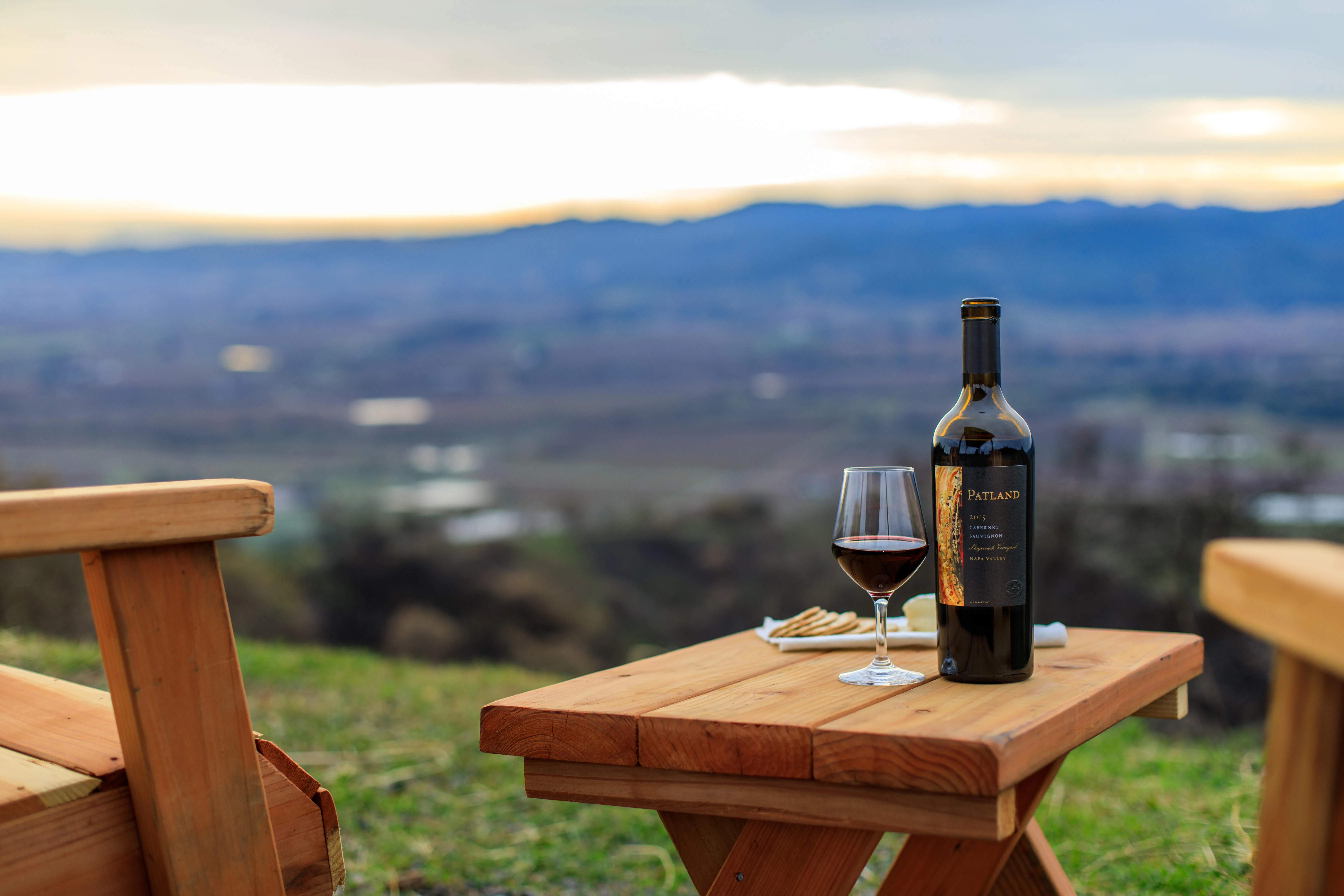 Patland Proprietary Red bottle and glass on an outdoor table