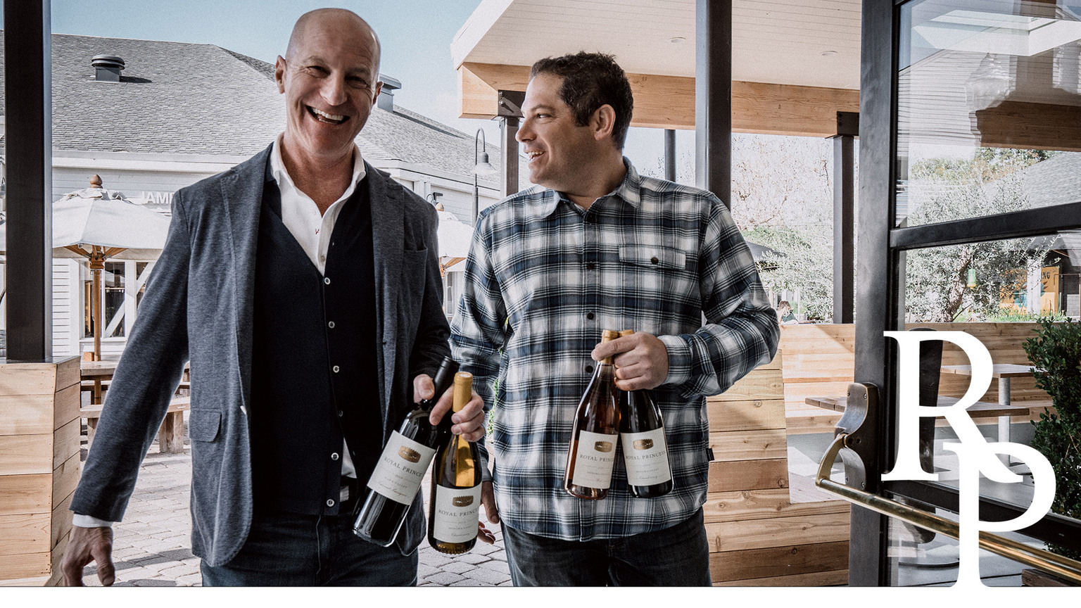 Royal Prince partners David Green and Maayan Koschitzky holding wine bottles
