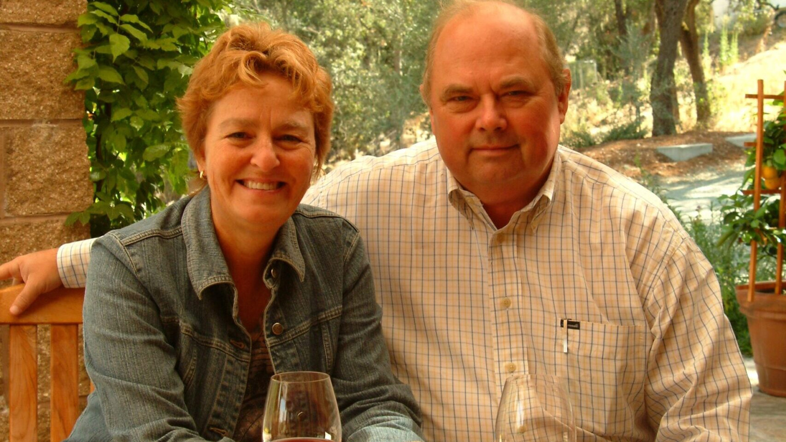 Barbara and Bruce Neyers seated together with glasses of red wine