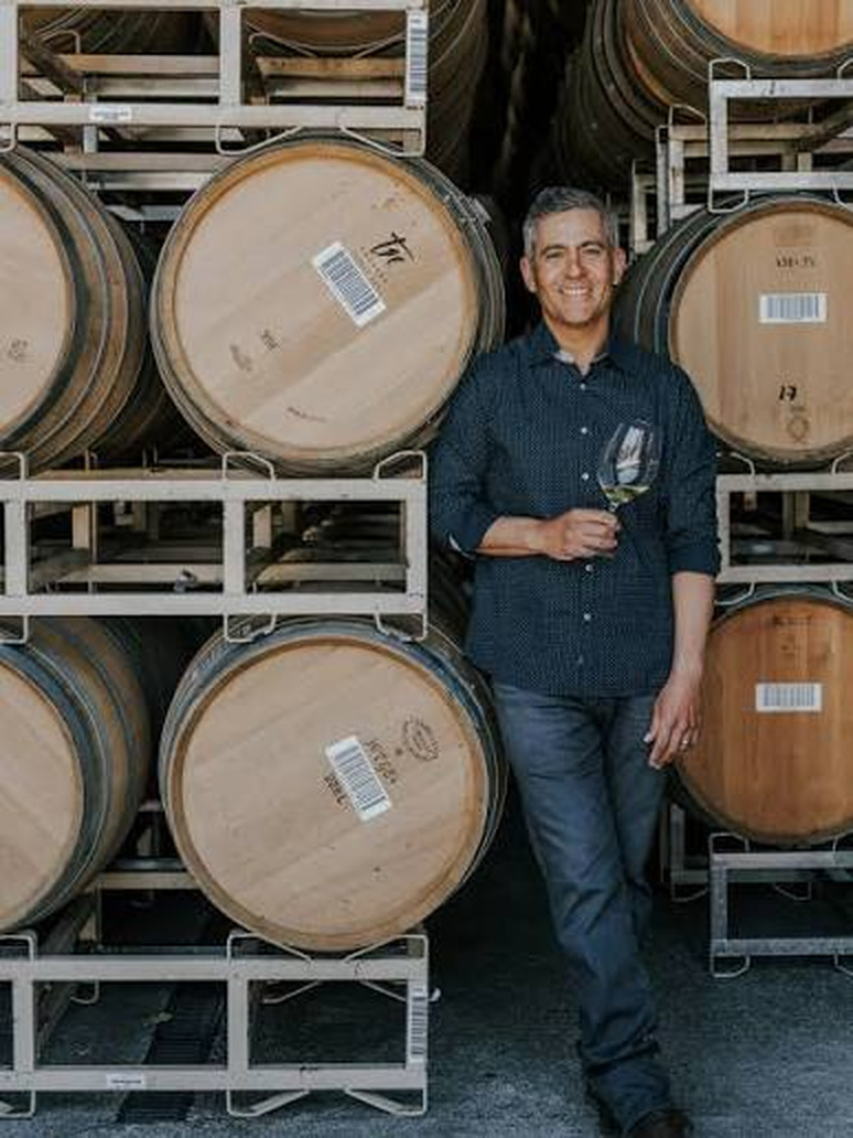 Winemaker Tadeo Borchardt beside French oak barrels