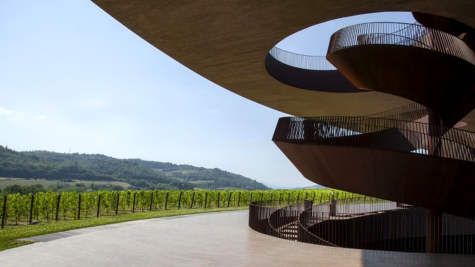 Corten spiral staircase at Antinori nel Chianti Classico overlooking Chianti vines