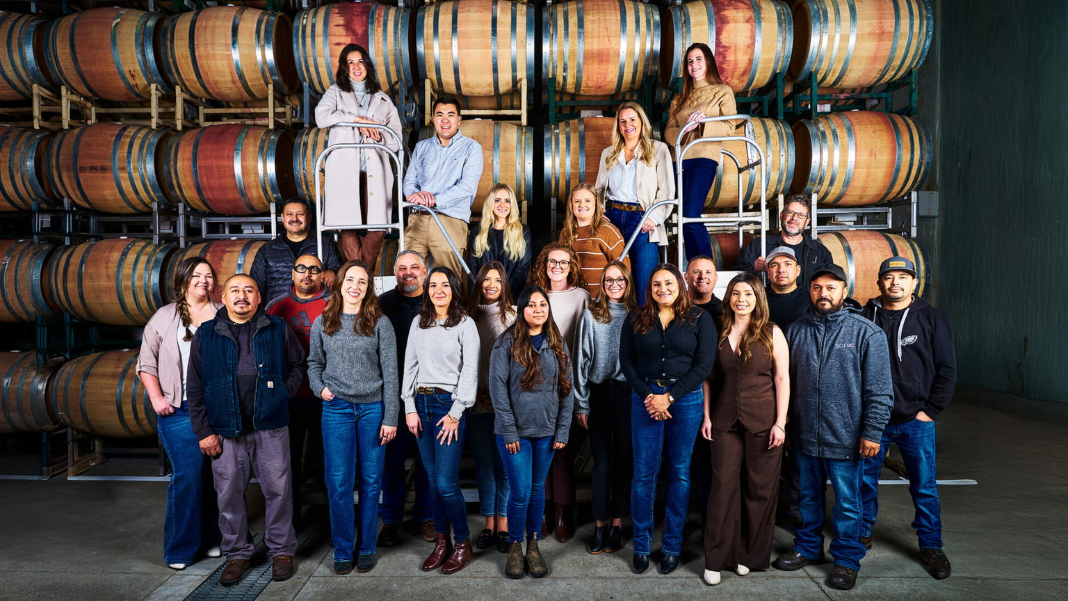 The J Vineyards team in front of barrel racks