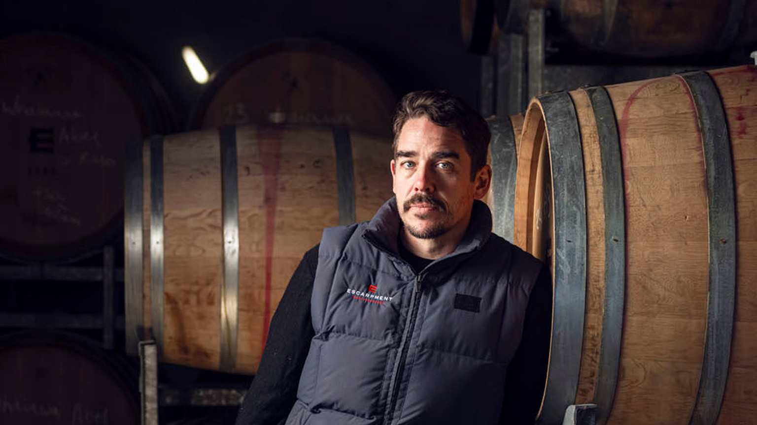 A man beside barrels in the Escarpment cellar