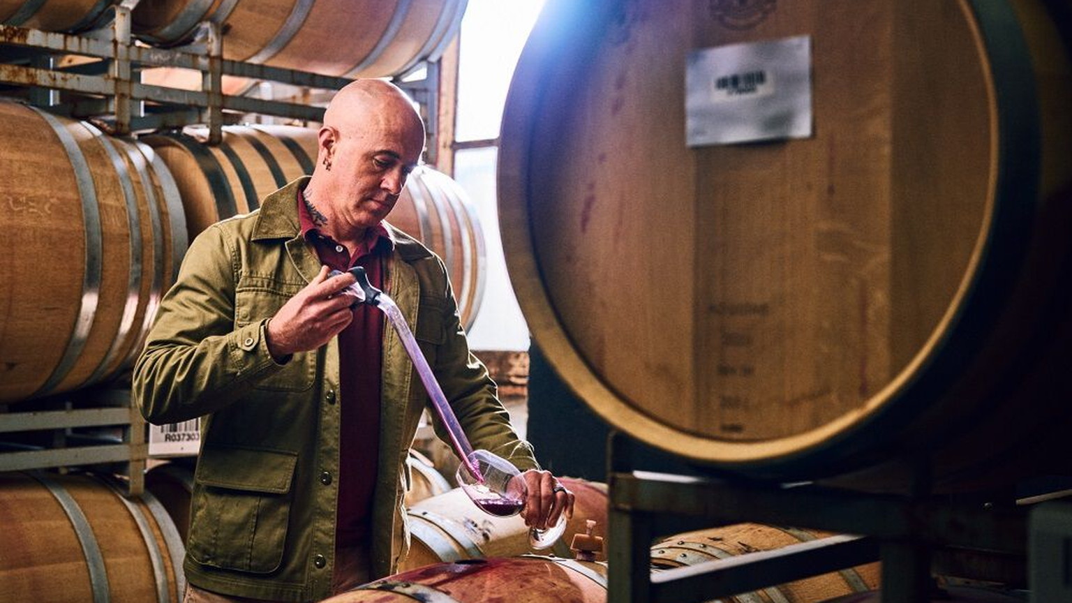 A Ravenswood winemaker beside a barrel