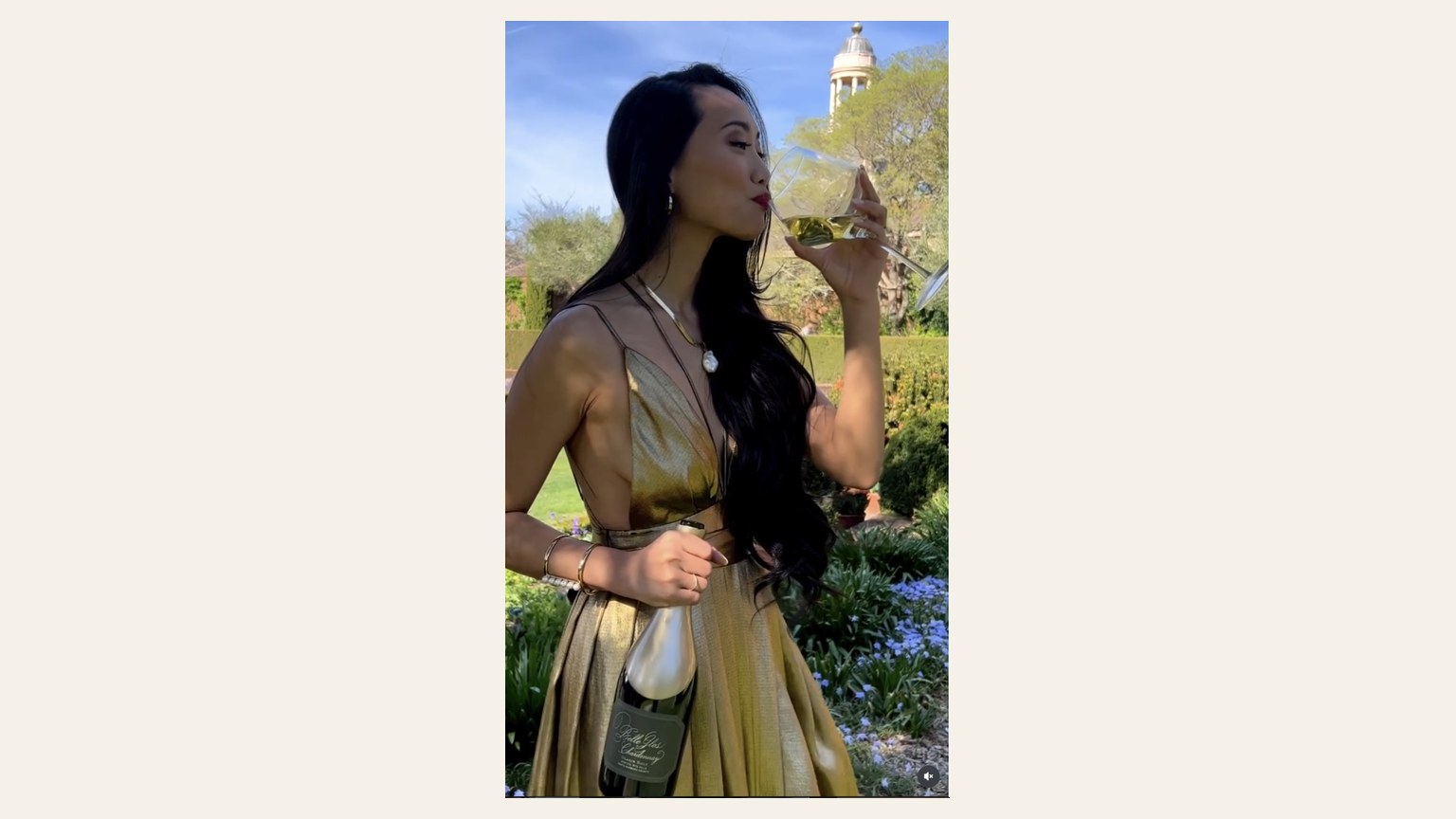 A guest drinking white wine and holding a Belle Glos Chardonnay bottle.