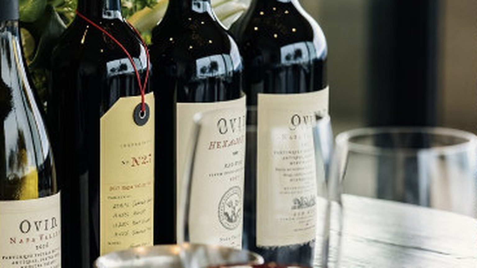 Three Ovid bottles and two glasses of red wine