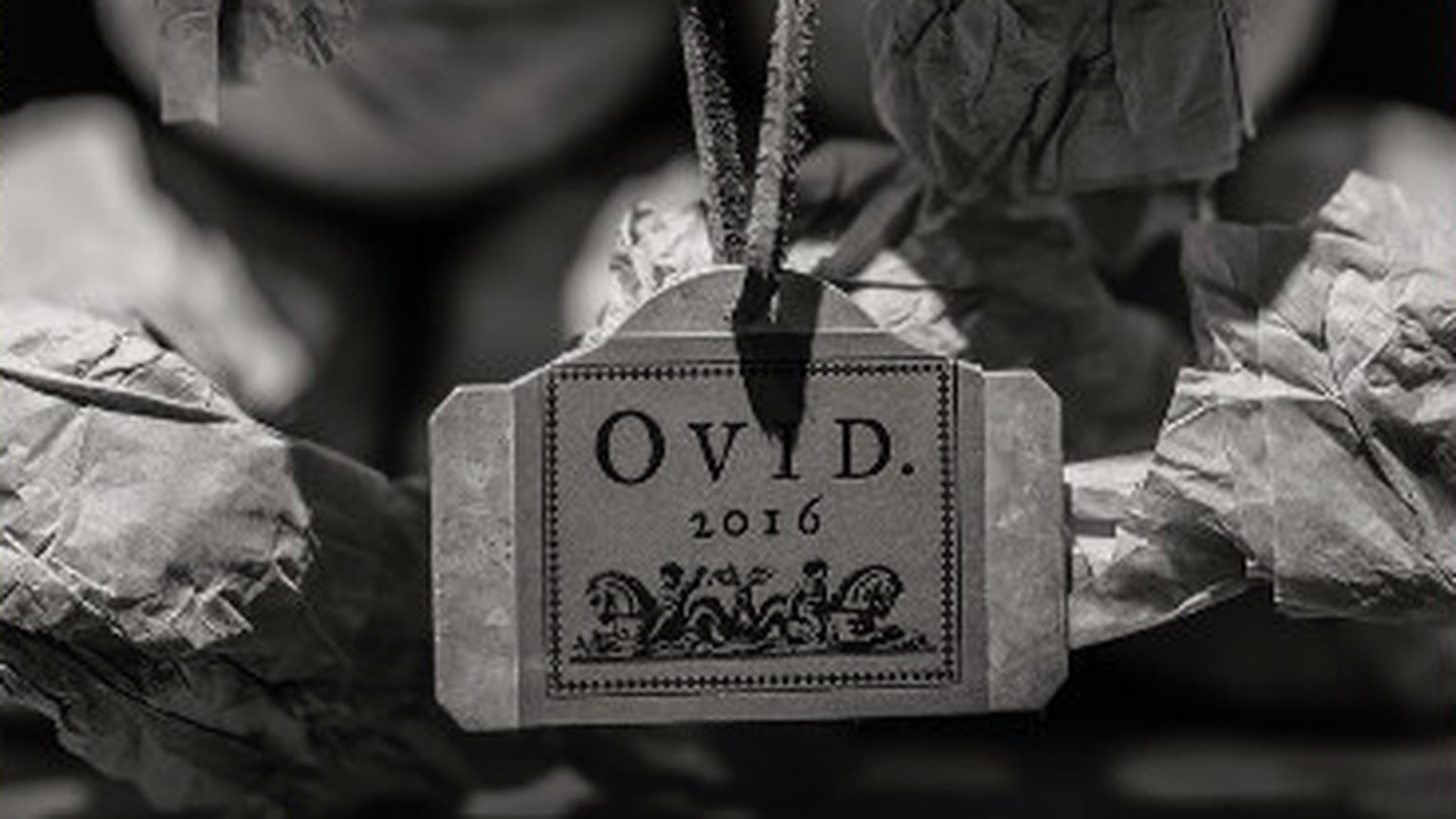 An Ovid cellar tag printed 2016, hanging on a wrapped bottle