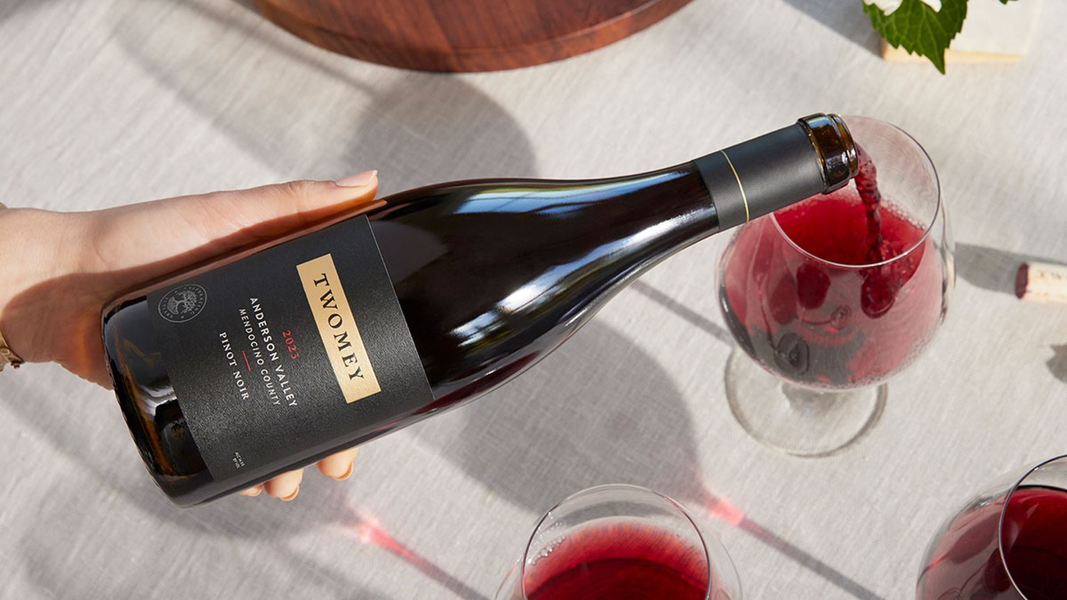 A hand pouring the 2023 Twomey Anderson Valley Pinot Noir