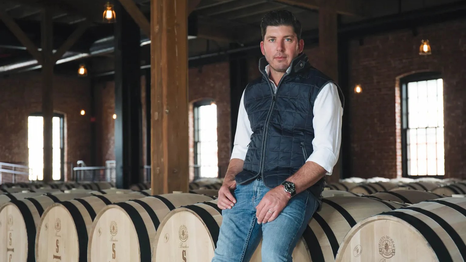 Dave Phinney seated on barrels in the cellar
