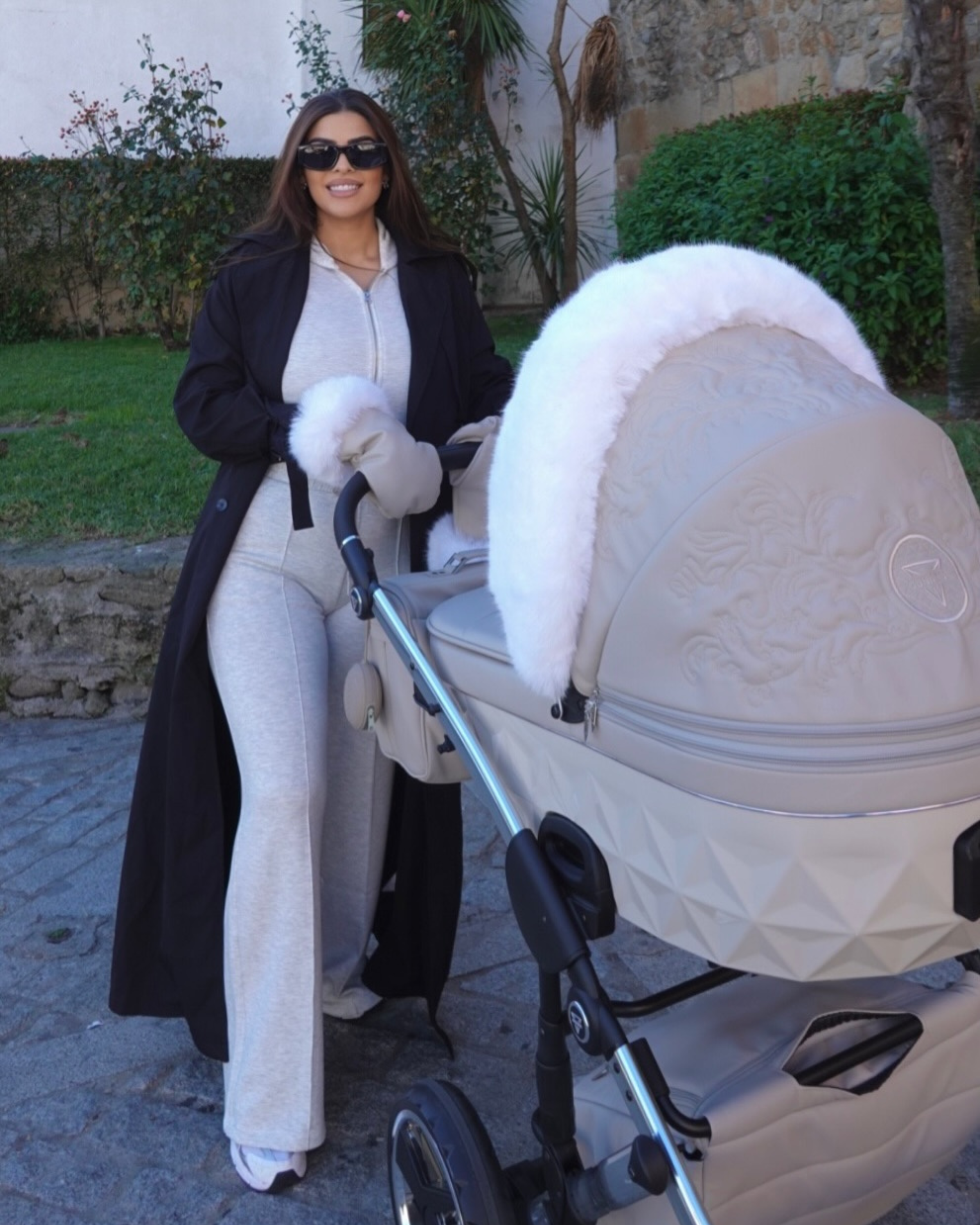 Junama Enzo Beige 2-in-1 pram with glamorous woman standing behind stroller in neutral luxury setting