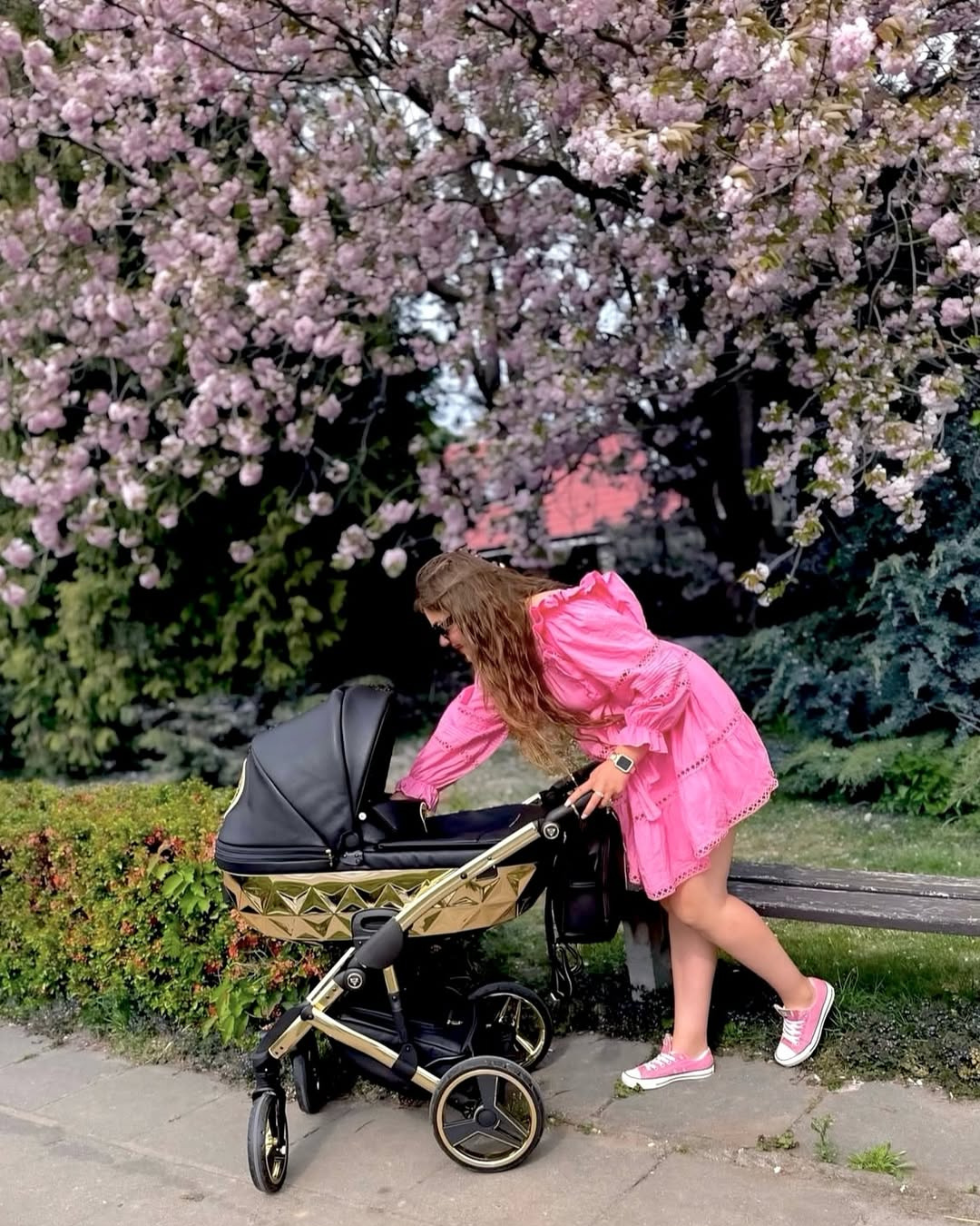 Junama Handcraft Black Gold 2-in-1 pram with glamorous mum standing behind baby stroller in outdoor setting