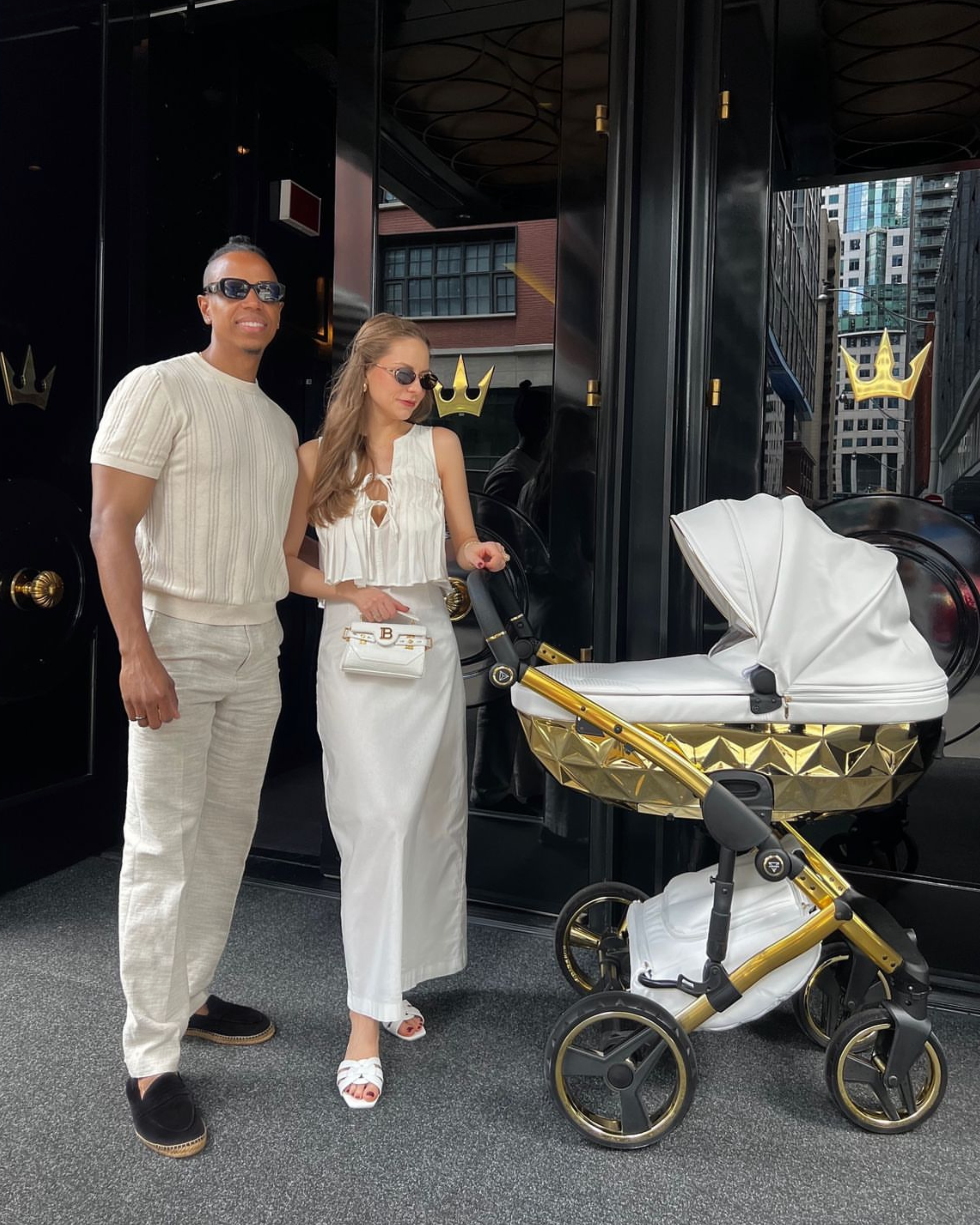 Handcraft White Gold 2-in-1 pram with glamorous parents standing behind pram in neutral luxury setting
