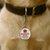 Service dog collar tag with bold Service Dog lettering and metal ring attachment hanging from a dog collar