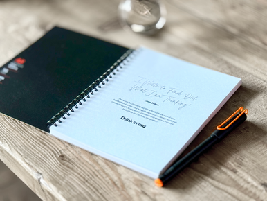 INQ smartpen with INQ notepad on a desk