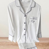 White satin long pyjama set with black piping and personalised pocket detail, ideal for bridal loungewear