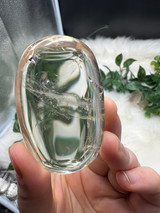 Shop this A Grade Clear Quartz Palmstone, featuring beautiful clarity and natural inclusions. A powerful crystal for focus, cleansing and energy amplification.