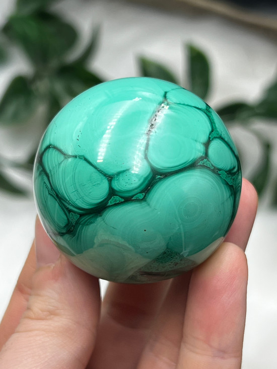 Beautiful Malachite sphere with rich green banding. A powerful crystal for protection, transformation, courage and breaking ties from the past.