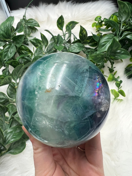 Discover an XL Rainbow Fluorite Sphere with stunning green, blue and purple tones and natural rainbow flash. A unique collector’s crystal for clarity and balance.
