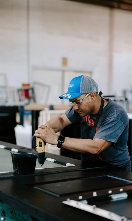 Worker measuring glass in shop