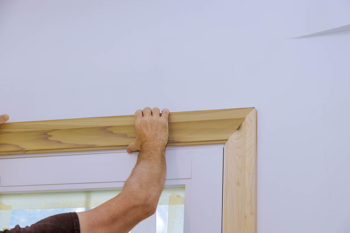 carpenter-installing-moldings-doors-nailing-framing-trim.jpg