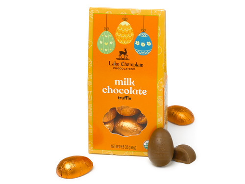 Milk chocolate truffle filled Easter eggs wrapped in orange foils and packaged in a dark and light orange Easter themed gift box, with wrapped and unwrapped eggs sitting outside of the gift box.