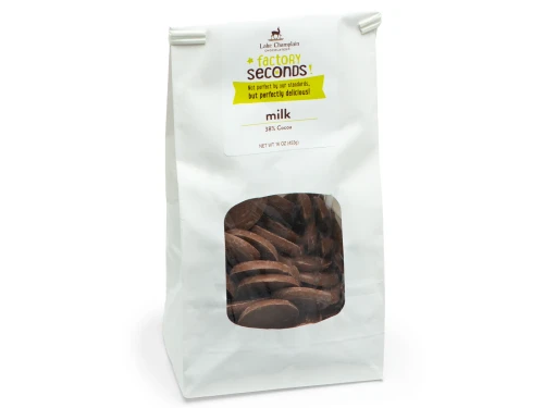 Factory seconds milk chocolate coins, packaged in a white bag with a clear window in the front.