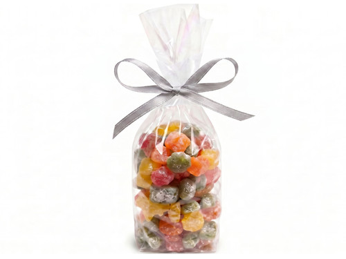 Clear gift bag  with a silver ribbon filled with various flavored sour gummies in the shape of stars, moons, clouds and suns.