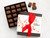 Milk chocolate covered sea salt caramels in a brown gift box with a cream label and a red bow. View Product Image