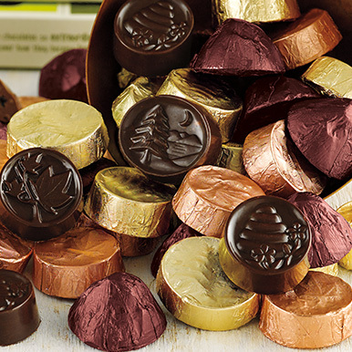Assorted Chocolates of Vermont pieces in a pile and spilling out of a bowl that's on it's side.