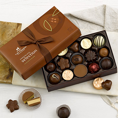 Assorted gourmet chocolates in a brown gift box.